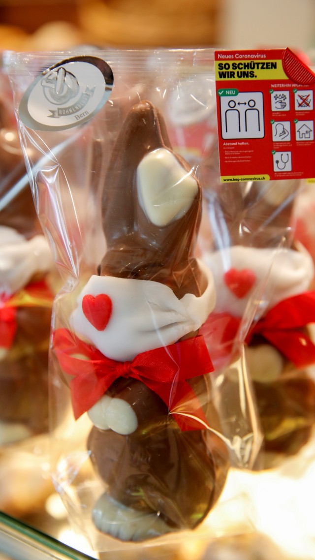 Coklat paskah berbentuk kelinci mengenakan masker dipajang di toko roti Bohnenblust di Bern, Swiss, Rabu (25/3). Foto: REUTERS/Arnd Wiegmann