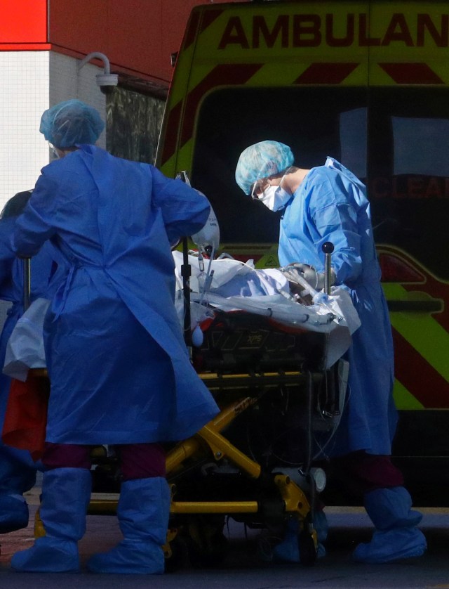 Petugas medis membawa pasien virus corona dari ambulans menuju rumah sakit S Thomas di London, Inggris. Foto: REUTERS/Hannah McKay