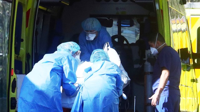 Petugas medis membawa pasien virus corona dari ambulans menuju rumah sakit S Thomas di London, Inggris. Foto: REUTERS/Hannah McKay