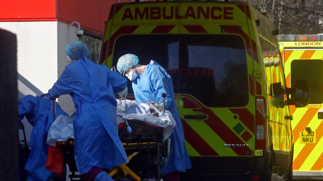 Petugas medis membawa pasien virus corona dari ambulans menuju rumah sakit S Thomas di London, Inggris. Foto: REUTERS/Hannah McKay