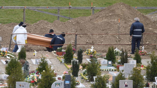 Petugas menguburkan warga yang meninggal karena virus corona di Italia. Foto: REUTERS/Daniele Mascolo