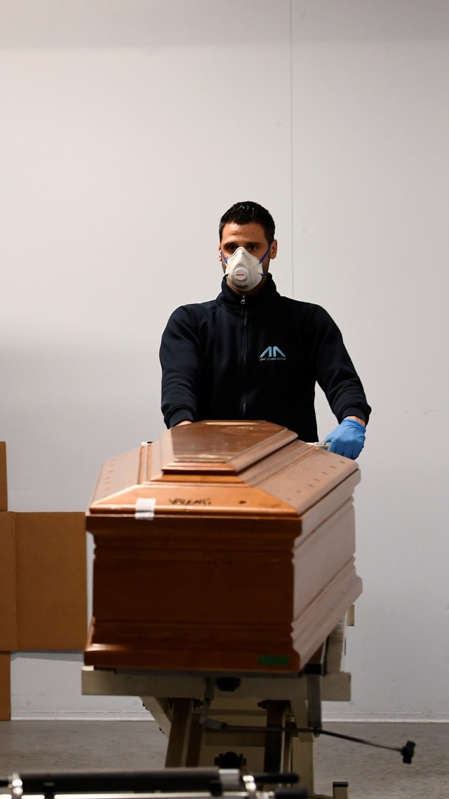 Petugas menyiapkan peti mati untuk korban virus corona (COVID-19) di gereja pemakaman Serravalle Scrivia, Italia. Foto: REUTERS / Flavio Lo Scalzo
