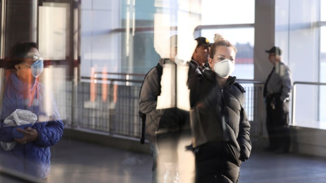 Sejumlah pejalan kaki mengenakan masker selama wabah virus corona di Manhattan, New York, AS. Foto: REUTERS/Caitlin Ochs