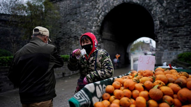 Pedagang buah menggunakan masker di Jingzhou, Hubei. Foto: Reuters/Aly Song