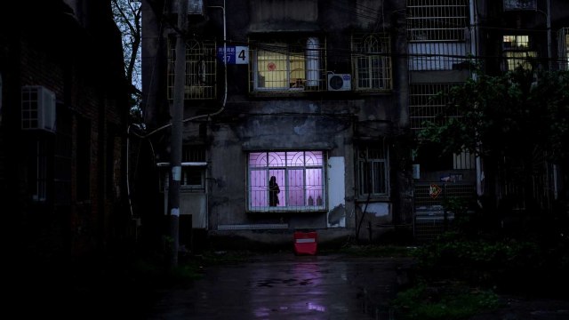 Warga berdiam di dekat jendela di Jingzhou, Hubei. Foto: Reuters/Aly Song