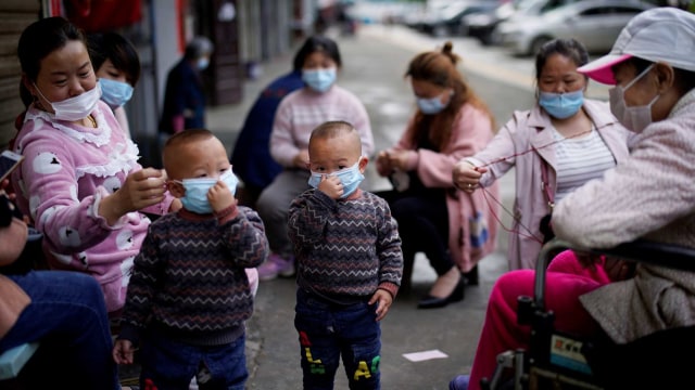 Anak-anak bersama orang dewasa di Xianning beraktivitas menggunakan masker. Foto: Reuters/Aly Song