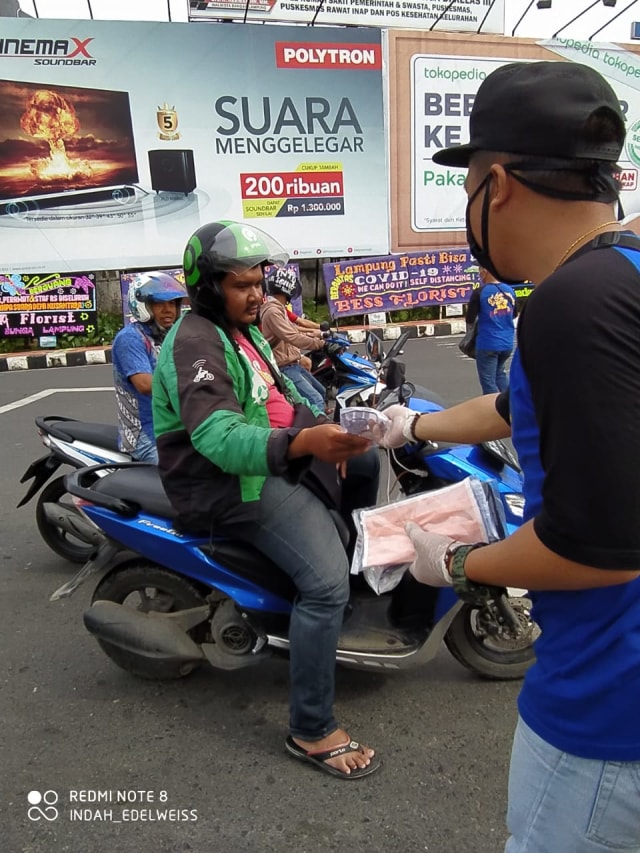 Pengendara ojek online mendapatkan masker gratis dalam kegiatan pembagian masker gratis oleh Asosiasi Sanggar Bunga Lampung (ASBL), Jumat (27/3) | Foto: AS Farid