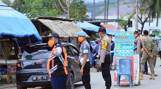 Petugas kepolisian, dinas perhubungan dan Satuan Polisi Pamong Praja berjaga-jaga di daerah perbatasan antara Kabupaten Bolmut, Sulawesi Utara dan Provinsi Gorontalo (foto: humas pemkab bolmut)