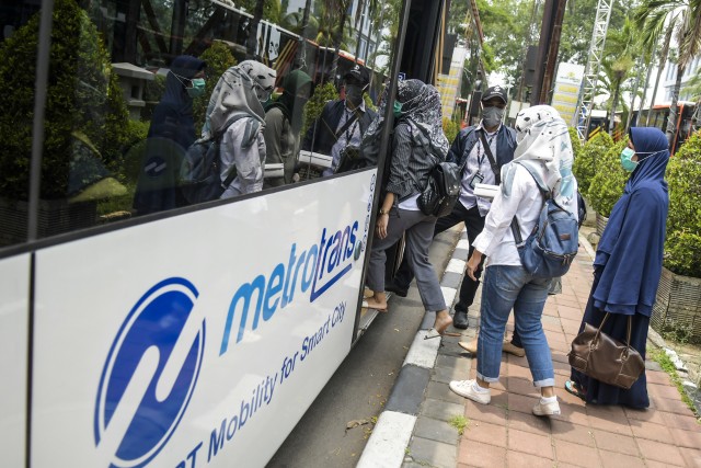 Para tenaga medis menaiki bus Transjakarta yang disiapkan oleh Pemprov DKI, Sabtu (28/3/2020).  Foto: Antara/Galih Pradipta