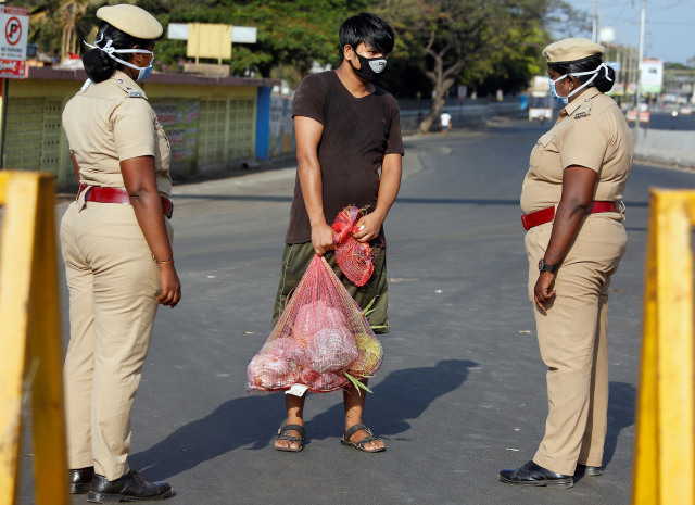 Petugas kepolisian menyetop warga yang keluar rumah saat lockdown di Chennai, India, Rabu (25/3). Foto: Reuters/P. Ravikumar