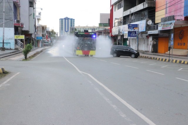 Penyemprotan cairan disinfektan oleh petugas kepolisian di tengah Kota Jayapura yang terlihat sepi akibat pandemi Virus Corona. (Foto dok Humas Polda Papua)