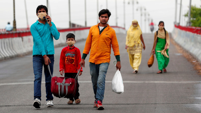 Sushil Kumar, seorang pekerja migran, berjalan di sepanjang jalan raya di Gajraula, di negara bagian Uttar Pradesh. Foto: REUTERS/Adnan Abidi