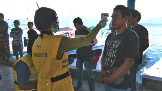DKP Sulteng dan petugas kesehatan Pelabuhan Donggala melakukan pemeriksaan suhu tubuh terhadap nelayan Donggala yang baru saja tiba di Pelabuhan Perikanan Donggala. Foto: Dok. Dinas Kelautan dan Perikanan Sulawesi Tengah