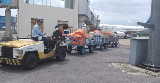 Anggota TNI membawa APD dari bagasi pesawat Garuda Indonesia di Bandara Haluoleo Sultra. Foto: Istimewa.