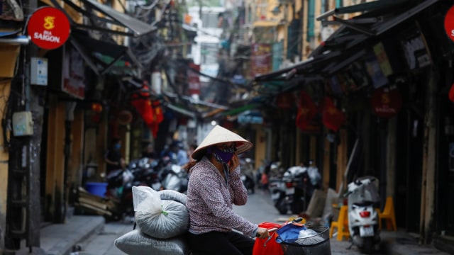  Seorang warga melintas di pasar Kota Hanoi, Vietnam, jelang penerapan Lockdown Foto: REUTERS