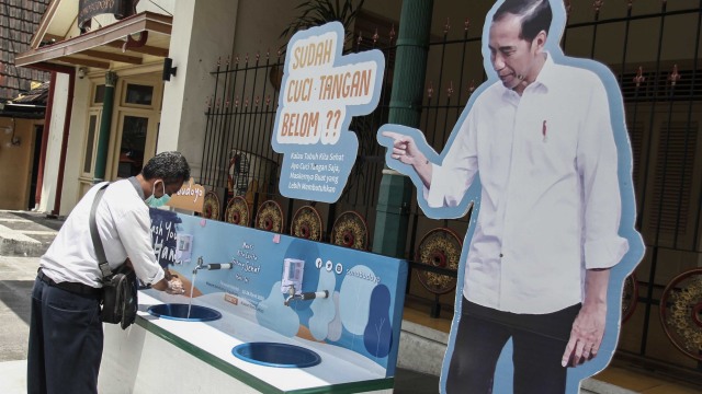 Warga mencuci tangan di area cuci tangan untuk publik di depan Museum Sonobudoyo, DI Yogyakarta, Senin (30/3/2020).  Foto: Antara/Hendra Nurdiyansyah