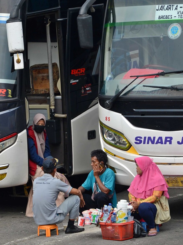 Pedagang menjajakan makanan kepada calon penumpang bus di Terminal Kampung Rambutan, Jakarta, Senin (30/3/2020). Foto: Antara/Aditya Pradana Putra