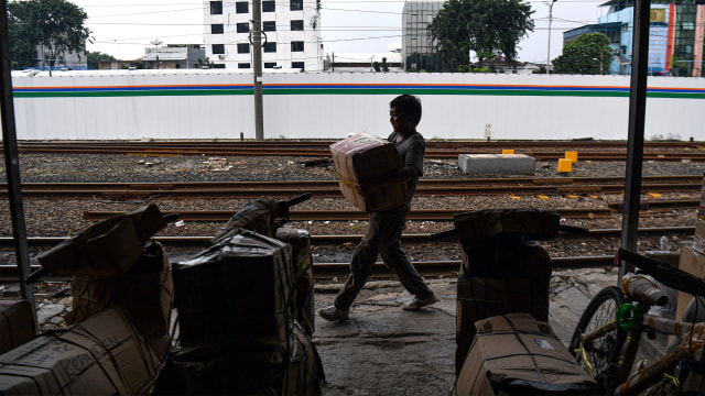 Pekerja mengangkut barang yang akan dikirim melalui kereta api di Stasiun Pasar Senen, Jakarta Pusat. Foto: ANTARA FOTO/Sigid Kurniawan
