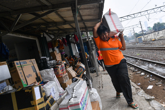 Pekerja mengangkut barang yang akan dikirim melalui kereta api di Stasiun Pasar Senen, Jakarta Pusat. Foto: ANTARA FOTO/Sigid Kurniawan