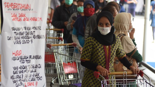 Warga antre berbelanja saat pemberlakuan pembatasan pengunjung supermarket di Tiptop, Depok, Jawa Barat, Senin (30/3/2020). Foto:  ANTARA FOTO/Indrianto Eko Suwarso