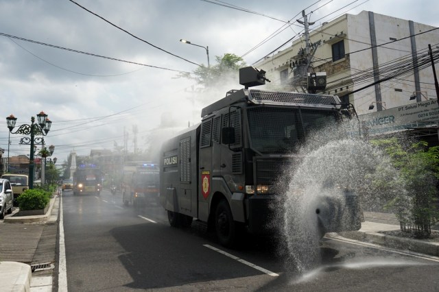 Polisi menyemprotkan cairan disinfektan menggunakan kendaraan taktis di kawasan Tugu Pal Putih, Daerah Istimewa Yogyakarta (DIY), Selasa (31/3). Foto:  ANTARA FOTO/Andreas Fitri Atmoko