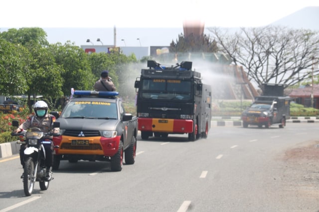 Mobil water cannon polisi menyemprotkan cairan disinfektan pada jalan protokol di wilayah Kota Banda Aceh, Selasa (31/3). Foto: Dok. Polda Aceh
