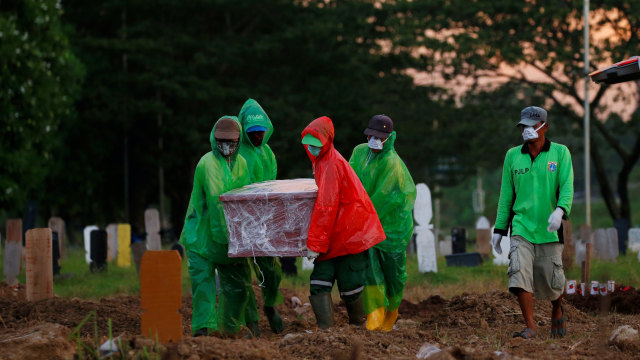 Sejumlah petugas membawa peti mati jenazah korban penyakit COVID-19 di Taman Pemakaman Umum (TPU), Jakarta, Selasa (31/3/). Foto: Reuters/Willy Kurniawan