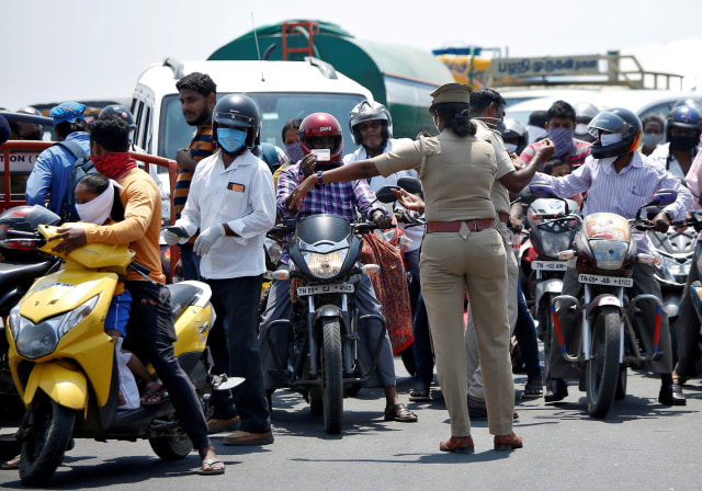 Petugas polisi menghentikan para pengendara, selama lockdown, di Chennai, India, Rabu (1/4). Foto:  REUTERS/P. Ravikumar