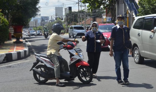Aksi wartawan PWI Lampung bagikan masker dan hand sanitizer kepada pengendara motor, Rabu (1/4) | Foto : PWI Lampung