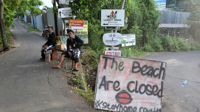 Pecalang atau petugas pengamanan adat Bali berjaga di sekitar kawasan wisata Pantai Balangan yang ditutup sementara di Badung, Bali. Foto: ANTARA FOTO/Fikri Yusuf