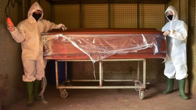Pekerja kamar mayat menyiapkan peti mati untuk korban wabah coronavirus COVID-19 di Bekasi, Jawa Barat, Rabu (1/4). Foto: REZAS / AFP
