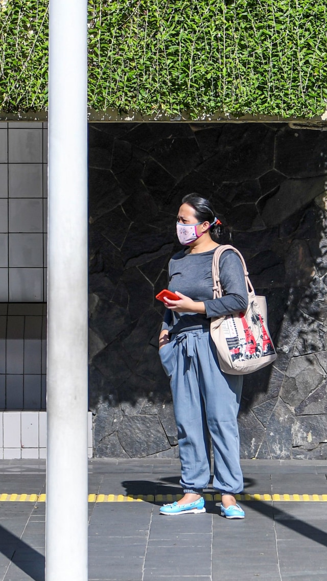 Warga mengenakan masker saat menunggu ojek daring di jalan MH Thamrin, Jakarta. Foto: ANTARA FOTO/Nova Wahyudi