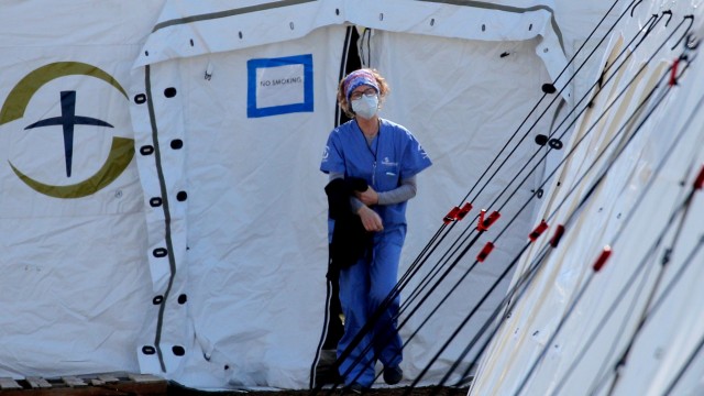 Seorang petugas medis berjalan di luar rumah sakit sementara untuk pasien virus corona di East Meadow Central Park New York, AS. Foto: REUTERS/Brendan Mcdermid