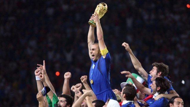 Cannavaro (mengangkat piala) dan Timnas Italia ketika menjuarai Piala Dunia 2006. Foto: PATRIK STOLLARZ / AFP
