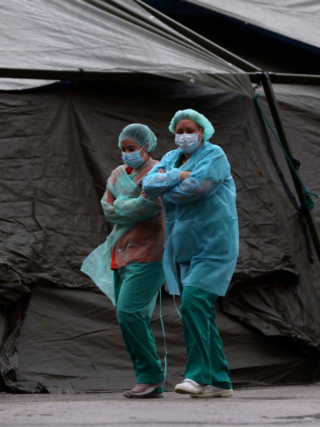 Petugas medis berjalan melewati tenda di rumah sakit Gregorio Maranon. Foto: REUTERS/Susana Vera