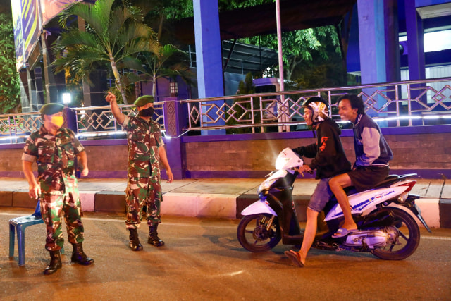 Aparat TNI menjaga jalan saat jam malam di Aceh. Foto: Suparta/acehkini