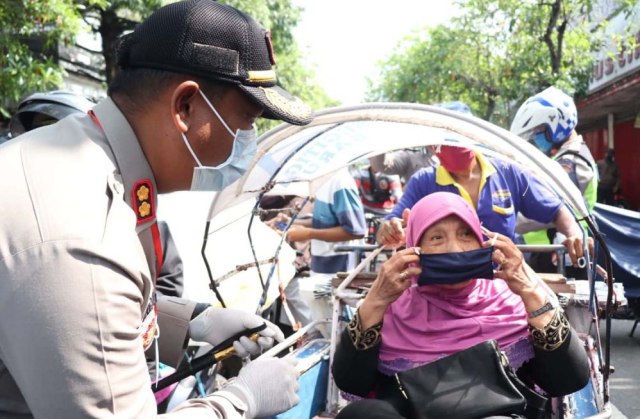 Kapolres Tulungagung AKBP Eva Guna Pandia memberikan masker gratis untuk salah satu warga