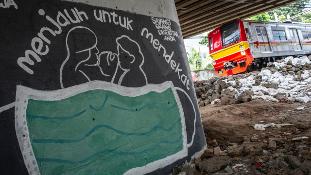 KRL melintas di dekat mural bertema pencegahan penyebaran virus Corona atau COVID-19 di Jakarta. Foto: ANTARA FOTO/Aprillio Akbar