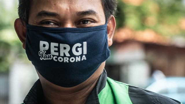 Pengemudi ojek daring menggunakan masker saat pembagian makanan gratis di kawasan Menteng, Jakarta, Jumat (3/4/2020). P Foto: Antara/Aprillio Akbar