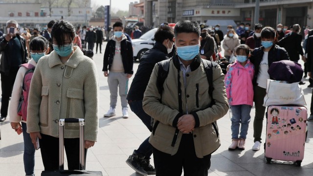 Warga China mengheningkan cipta untuk mengenang jasa petugas medis melawan virus corona. Foto: Reuters/Thomas Peter