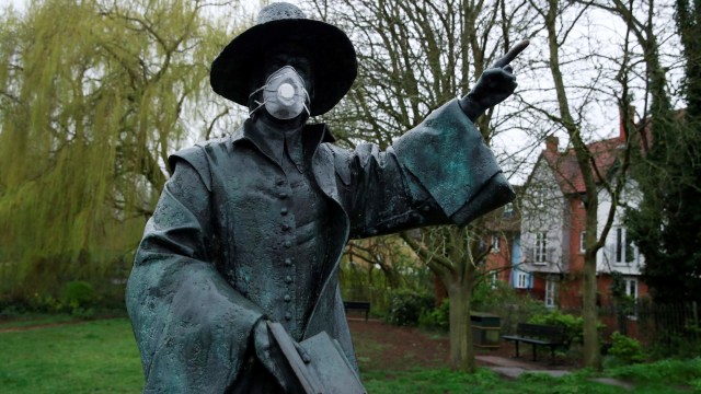 Sebuah patung di Hertford, Inggris menggunakan masker. Foto: REUTERS/Andrew Couldridge