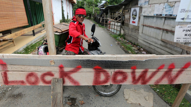 Pengendara berputar arah akibat adanya karantina wilayah mandiri atau penutupan jalan akses masuk ke permukiman penduduk di Banda Aceh, Aceh. Foto: ANTARA FOTO/Irwansyah Putra