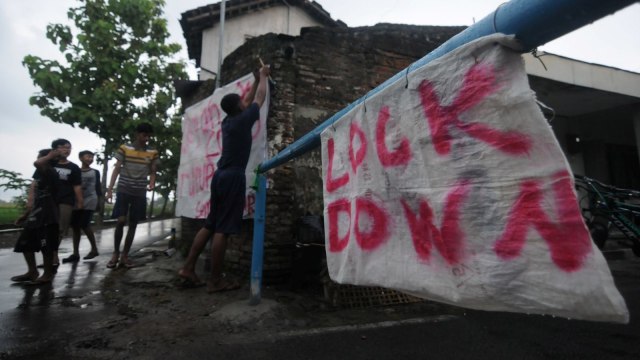 Warga memasang spanduk pada portal karantina wilayah di Bendosari, Sawit, Boyolali, Jawa Tengah. Foto: ANTARA FOTO/Aloysius Jarot Nugroho