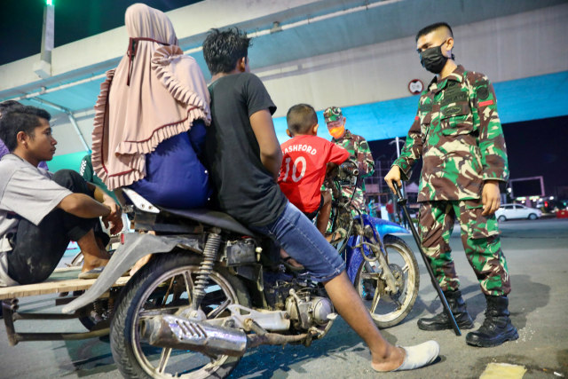 TNI meminta keluarga ini untuk cepat kembali ke rumah saat pemberlakuan jam malam di Aceh. Foto: Suparta/acehkini 