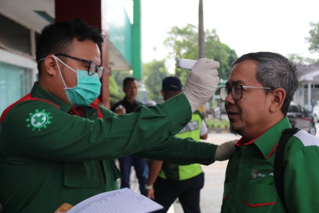 Pengecekan suhu tubuh bagi karyawan SMBR saat memasuki area kantor di Palembang. (foto: dok. istimewa)