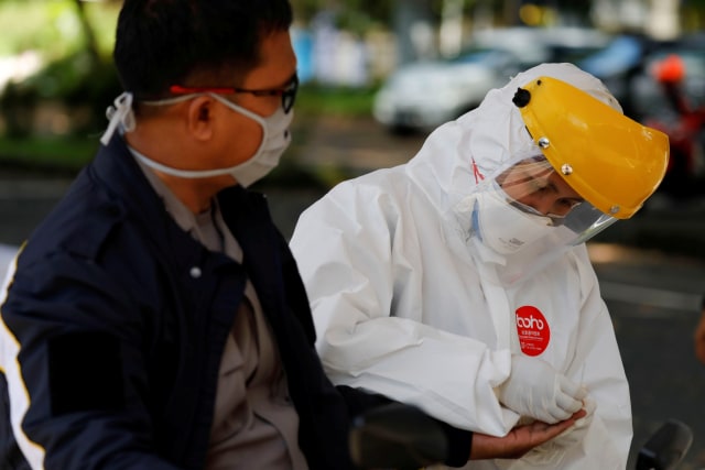 Petugas kesehatan mengambil sampel darah seorang pengendara untuk test virus corona, di Bogor, Selasa (7/4). Foto: REUTERS/Willy Kurniawan