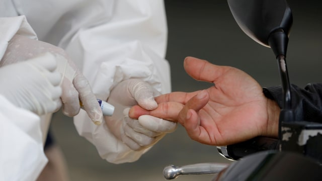 Petugas kesehatan mengambil sampel darah seorang pengendara untuk test virus corona, di Bogor, Selasa (7/4). Foto: REUTERS/Willy Kurniawan