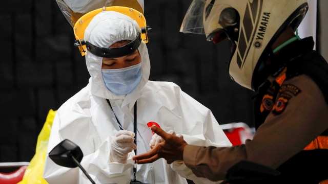 Petugas kesehatan mengambil sampel darah seorang polisi untuk test virus corona, di Bogor, Selasa (7/4). Foto: REUTERS/Willy Kurniawan