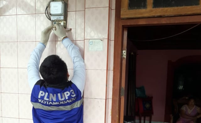 Petugas PLN memeriksa meteran listrik milik pelanggan