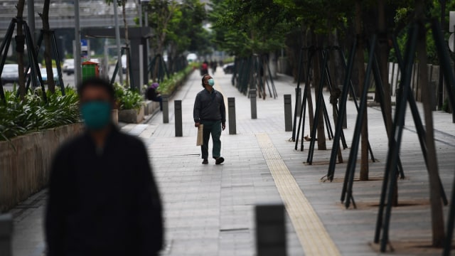 Pejalan kaki melintas di trotoar Jalan Jenderal Sudirman, Jakarta, Selasa (7/4). Foto: ANTARA FOTO/Akbar Nugroho Gumay